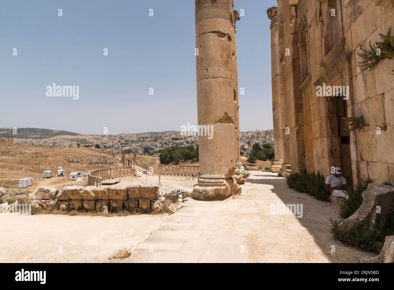 Mur et colonnes du temple de Zeus et du forum ovale en arrière-plan dans l'ancienne ville gréco-romaine de Gerasa dans l'actuelle Jerash, Jordanie. Banque D'Images