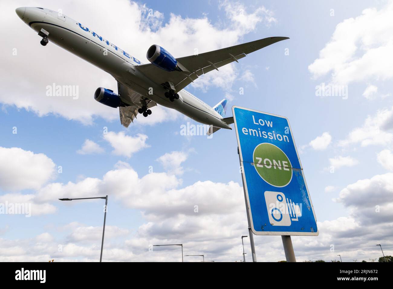 Panneau de zone de faible émission avec avion à réaction atterrissant à l'aéroport de Londres Heathrow, Royaume-Uni. Pollution atmosphérique. Émissions de dioxyde de carbone. Émissions de l'aviation. Signe de caméra Banque D'Images