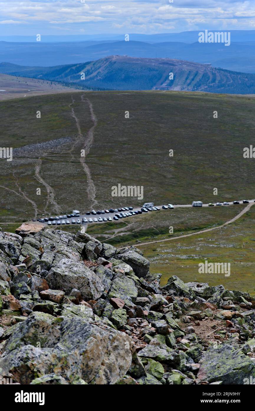 Au milieu de la nature scandinave à couper le souffle, vue surélevée du sommet de la montagne rocheuse ou affleurement sur les voitures garées, camping-cars et camping-cars, Suède Banque D'Images