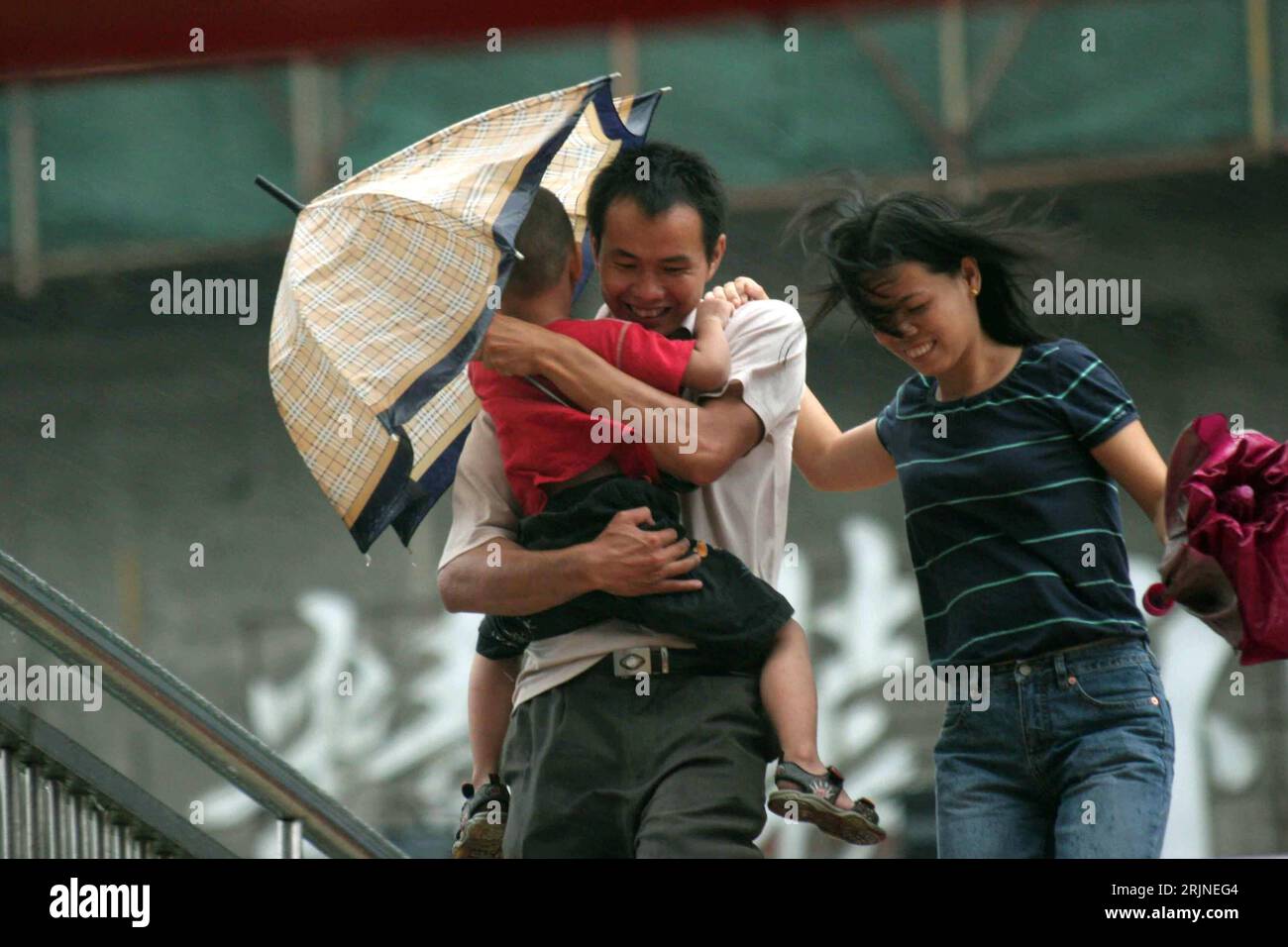 Bildnummer : 50920301 Datum : 01.09.2005 Copyright : imago/Xinhua Familie stemmt sich gegen den Sturm in Hangzhou - China, Personen ; 2005, Hangzhou, Vater, Mutter, Kind, Väter, Mütter, Familien, Eltern ; , quer, Kbdig, Gruppenbild, fermer, Chine, , / Taifun, Wirbelsturm, Wirbelstürme, Wetter, Unwetter, Stürme, Mann, Frau Banque D'Images