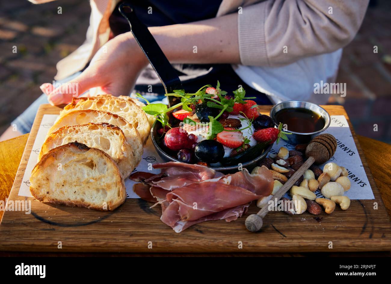 Plateau d'aliments variés, y compris pain de blé entier, salade et noix assorties Banque D'Images