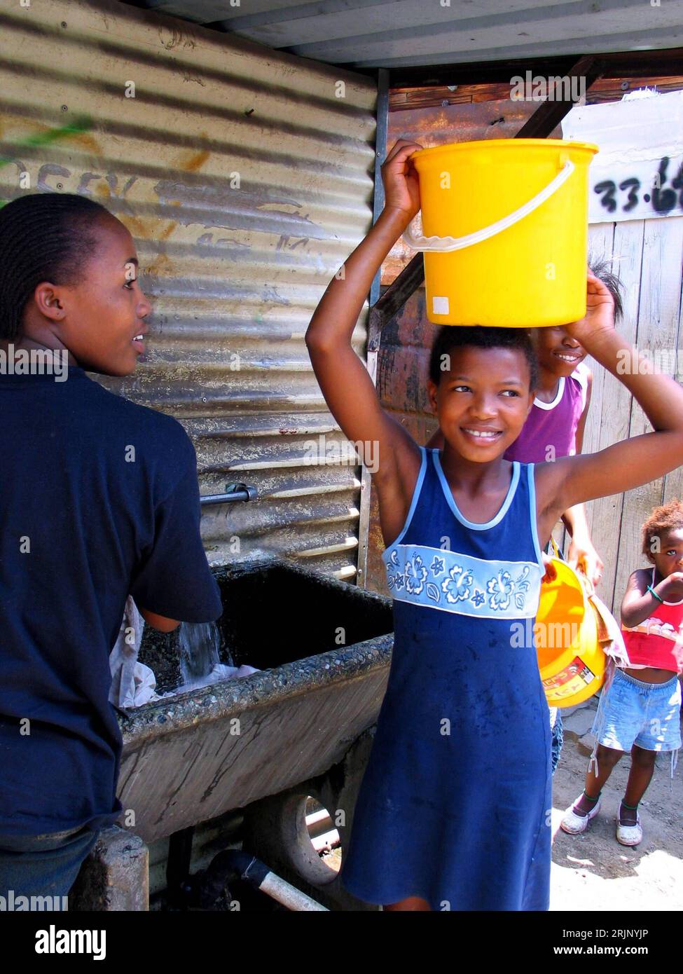 Bildnummer : 51038473 Date de référence : 04.12.2005 Copyright : imago/Xinhua Junges Mädchen mit einem Wassereimer auf dem Kopf in Johannesburg - PUBLICATIONxNOTxINxCHN, Personen , optimistisch ; 2005, Johannesburg, Südafrikaner, Südafrikanerin, Einheimischer, Einheimische, Land, Leute, trägt, tragend, Last, Lasten, transportieren, transportiert, transportierend, Eimer, lächelt; , hoch, Kbdig, Einzelbild, Südafrika, / Kinder ; Aufnahmedatum geschätzt Banque D'Images