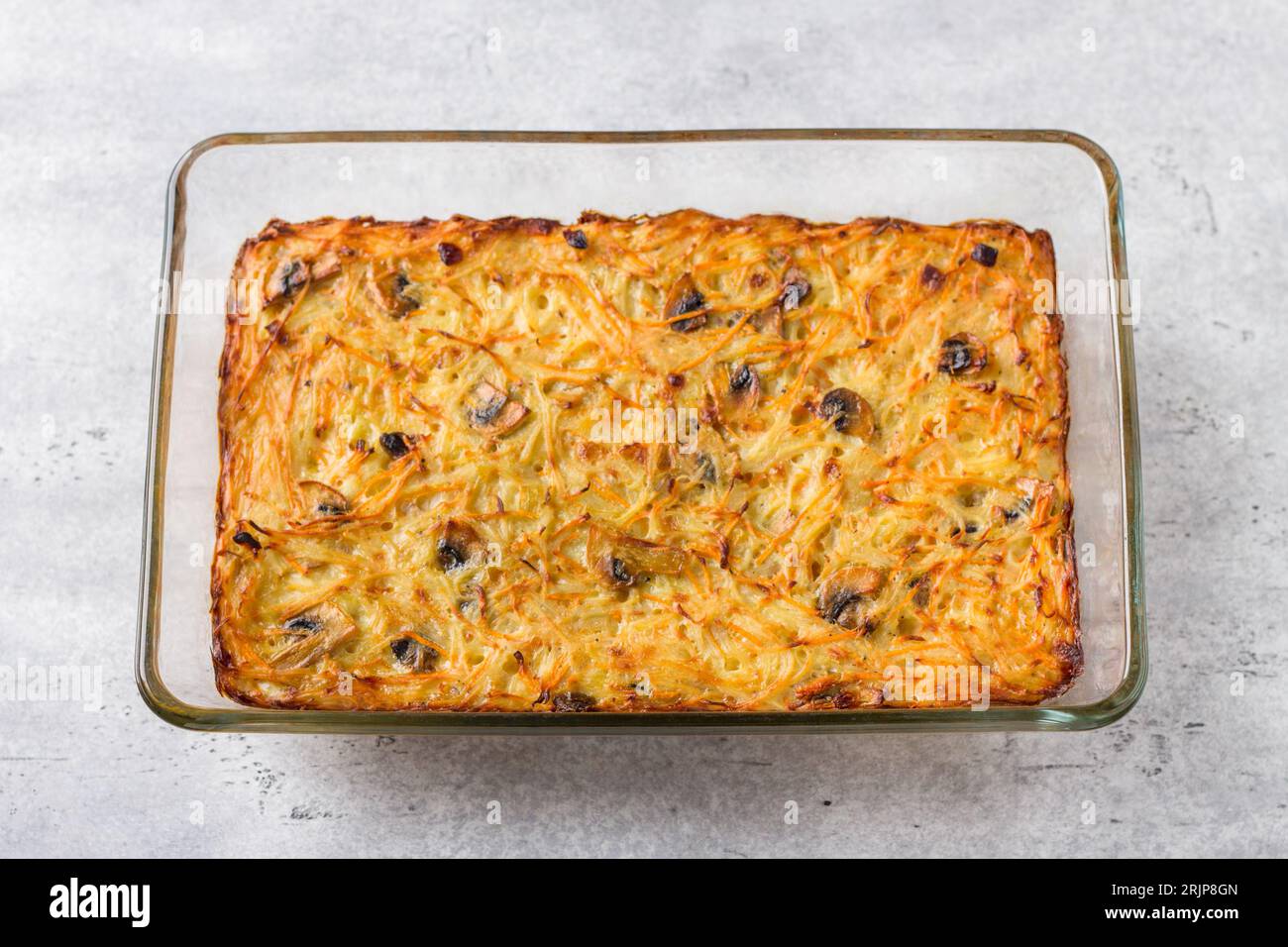 Plat de cuisson en verre avec gratin de pommes de terre fraîchement cuit, tarte ou casserole sur fond texturé gris, vue de dessus Banque D'Images