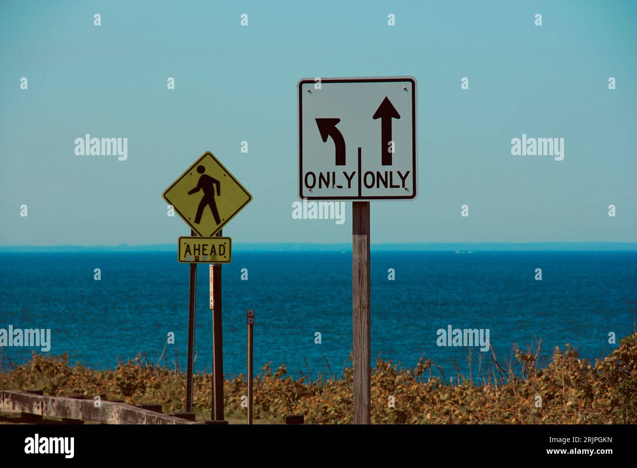 Un panneau de rue pour piétons à côté d'un panneau indiquant que vous ne pouvez aller que tout droit ou tourner à gauche Banque D'Images