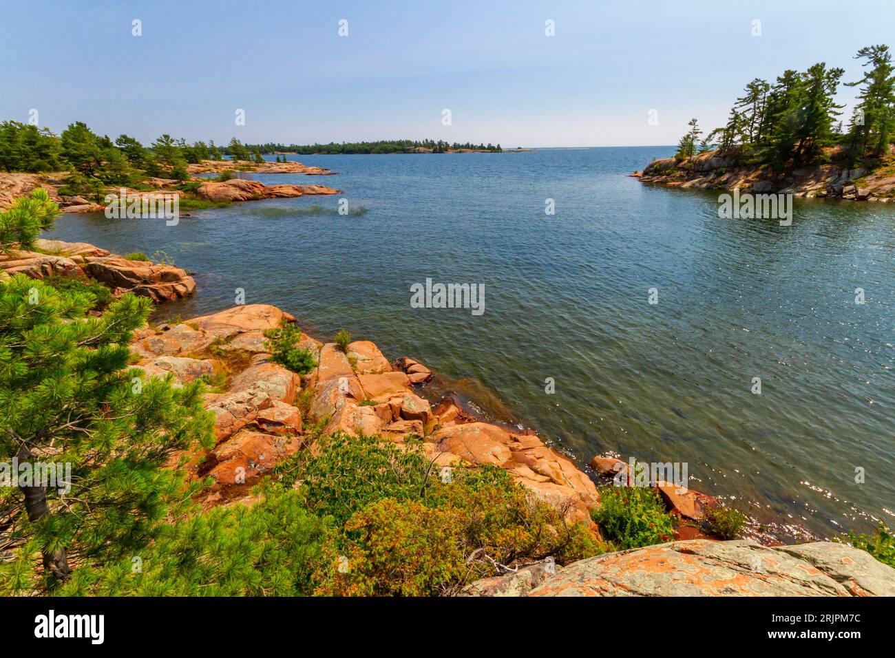 Rivage le long du lac Huron. Granite roches rouges à l'embouchure du ruisseau Chikanishing. Georgian Bay. Parc provincial Killarney, Ontario, Canada Banque D'Images