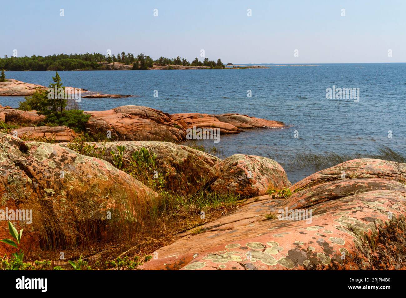 Rivage le long du lac Huron. Granite roches rouges à l'embouchure du ruisseau Chikanishing. Georgian Bay. Parc provincial Killarney, Ontario, Canada Banque D'Images