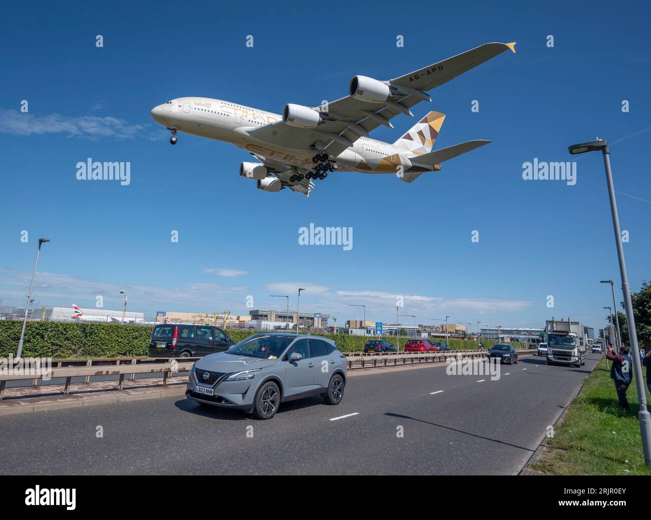 Heathrow, Londres, Royaume-Uni. 23 août 2023. La chaleur et le ciel bleu amènent les observateurs d'avions à voir les arrivées à l'aéroport de Londres Heathrow avec un Airbus A380 d'Etihad traversant au-dessus de la route A30 avec trafic. Crédit : Malcolm Park/Alamy Live News Banque D'Images