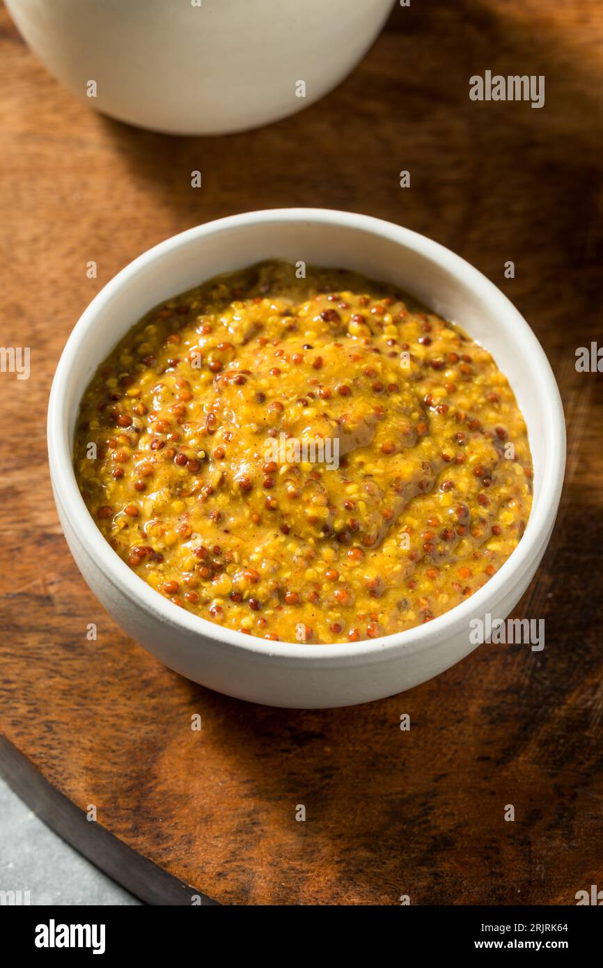 Moutarde grainée épicée bio brune dans un bol Banque D'Images