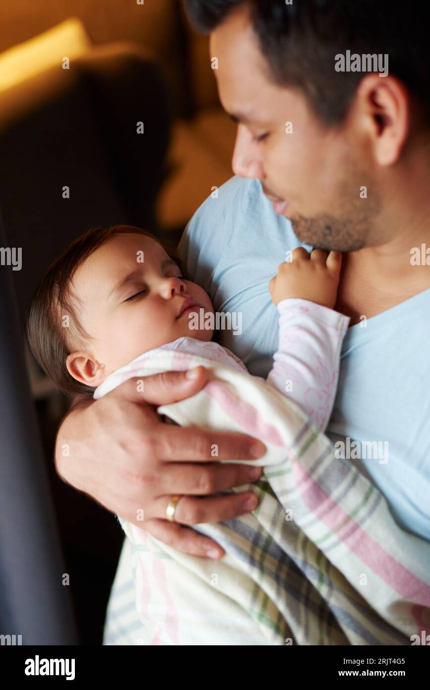 Père affectueux regardant une petite fille dormir dans ses bras Banque D'Images