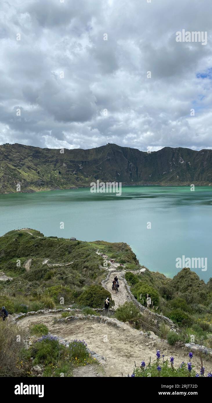 Vue spectaculaire sur la lagune de Quilotoa en Équateur, avec des montagnes pittoresques en arrière-plan et des voyageurs au premier plan profitant du paysage Banque D'Images
