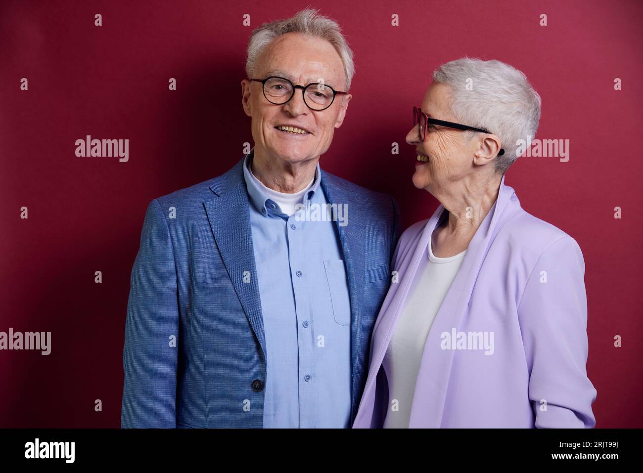 Femme senior regardant l'homme sur fond violet Banque D'Images