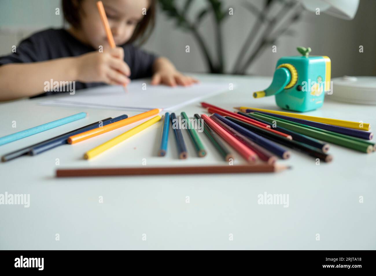 Garçon dessin avec des crayons de couleur sur la table à la maison Banque D'Images