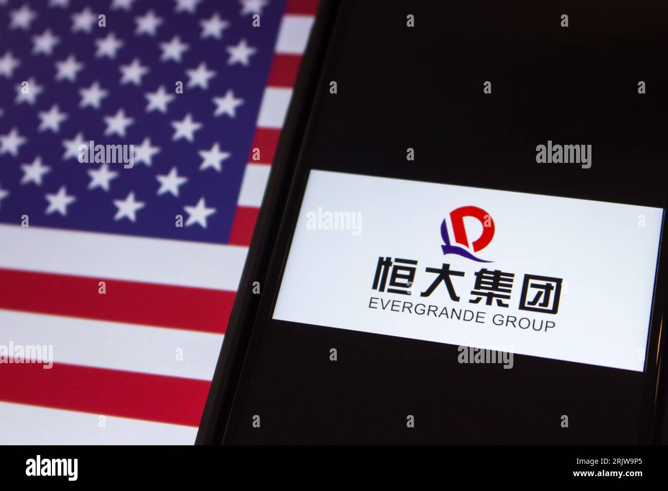 Logo du promoteur immobilier chinois le groupe China Evergrande vu dans iPhone sur drapeau des États-Unis. Le 2023 août, Evergrande Group a déposé une demande de faillite à New York Banque D'Images