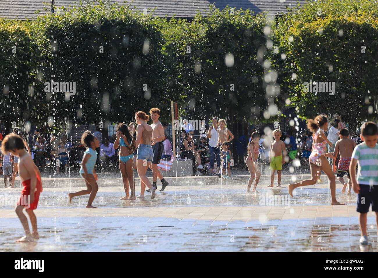 Londres, Royaume-Uni, 23 août 2023. Les familles ont profité du temps chaud et ensoleillé en jouant dans les fontaines de Granary Square, Kings Cross, au nord de Londres. Les températures ont finalement grimpé en flèche après un été misérable que les vacances scolaires approchent de la fin Crédit : Monica Wells/Alamy Live News Banque D'Images