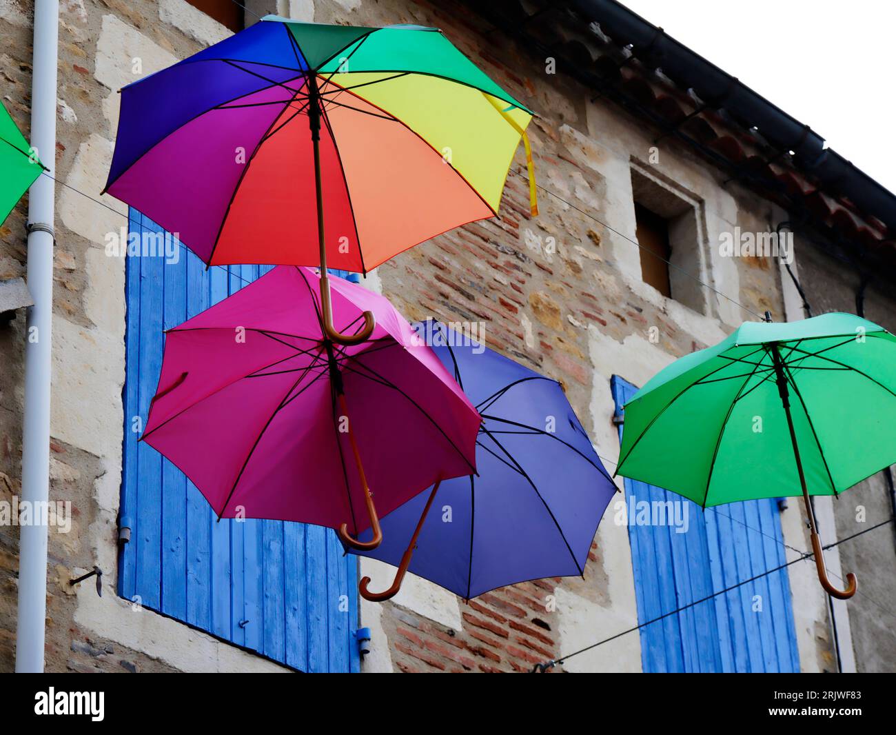 Parapluies colorés dans la rue à Puy l'Eveque Banque D'Images