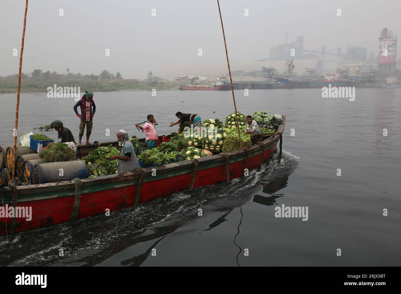 DHAKA, BANGLADESH-JANVIER 20 : des agriculteurs voyagent dans un bateau sur la rivière Shitalakhaya transportant des légumes pour leur vendre le marché de gros à Narayanganj près de Dhaka, Bangladesh le 20 janvier 2021. Banque D'Images