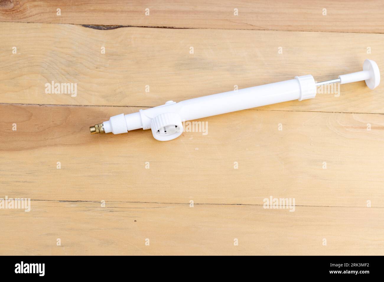 Pompe à gâchette de pulvérisateur en plastique sur fond en bois Banque D'Images Pompe à gâchette de pulvérisateur en plastique sur fond en bois Banque D'Images