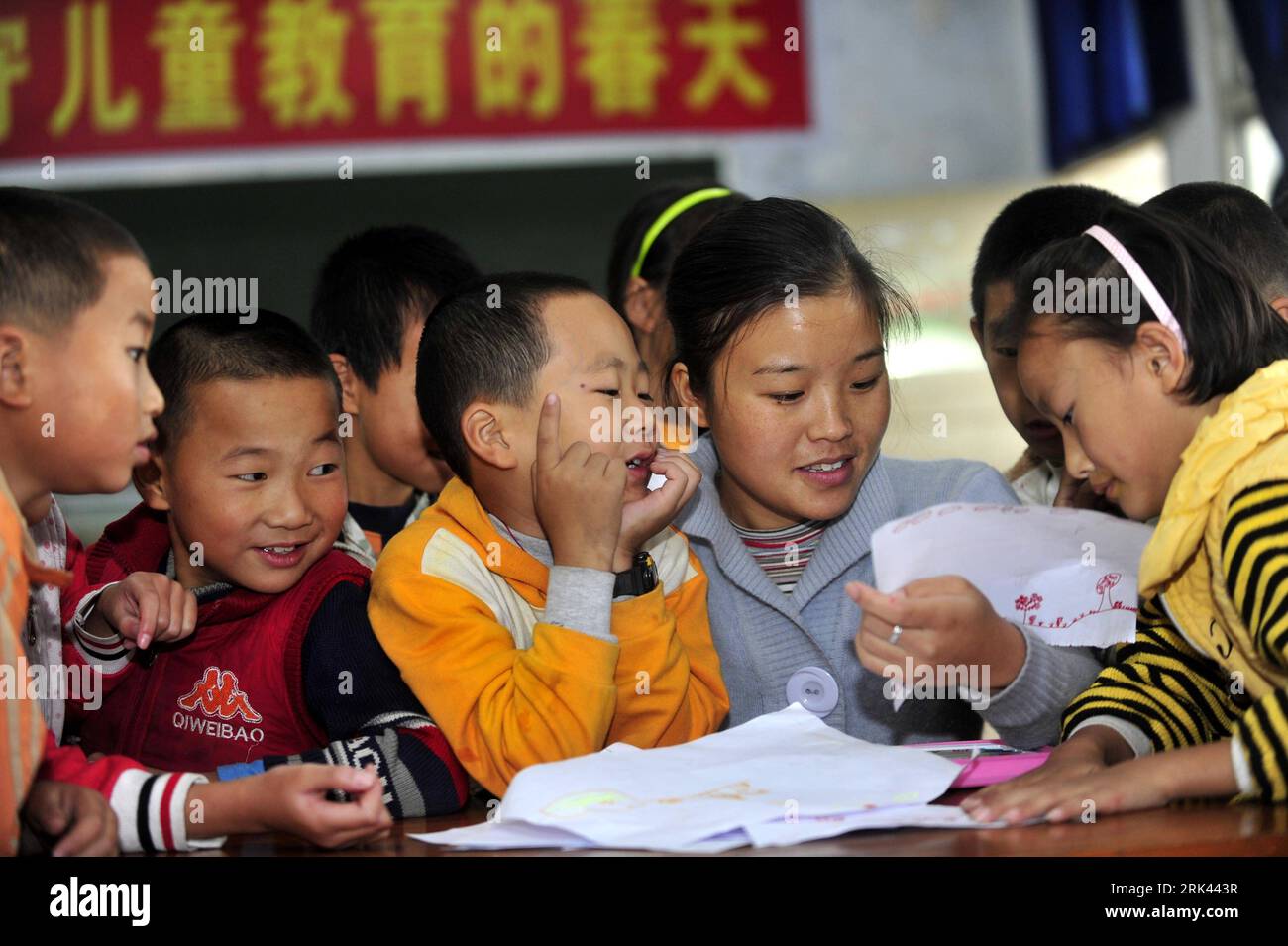 Bildnummer : 53585245 Datum : 12.10.2009 Copyright : imago/Xinhua (091108) -- ENSHI, 8 novembre 2009 (Xinhua) -- Zhu Xu montre une peinture à Zhou Xiaodan, son professeur, qui ressemble à sa mère, à l'école dans le comté de Xianfeng à Enshi, province du Hubei en Chine centrale, 12 octobre 2009. Zhu Xu, âgé de huit ans, était élève de 3e année de l'école primaire Boyangping Nationality. Un enfant comme lui était censé vivre heureux avec ses parents, mais dans sa mémoire, il n'avait pas un tel bonheur. Son père Zhu Gang avait quitté la maison pour chercher du travail depuis 1994. En 2001, après la naissance de Zhu Xu, sa mère est également allée au sud Banque D'Images