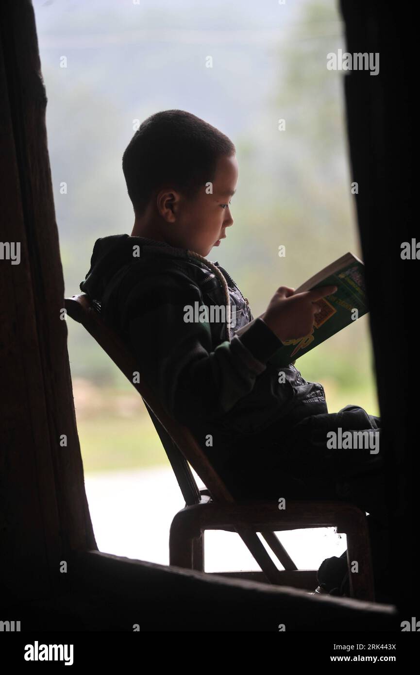 Bildnummer : 53585247 Datum : 11.10.2009 Copyright : imago/Xinhua (091108) -- ENSHI, 8 novembre 2009 (Xinhua) -- Zhu Xu lit un livre à la maison dans le comté de Xianfeng à Enshi, province du Hubei en Chine centrale, 11 octobre 2009. Zhu Xu, âgé de huit ans, était élève de 3e année de l'école primaire Boyangping Nationality. Un enfant comme lui était censé vivre heureux avec ses parents, mais dans sa mémoire, il n'avait pas un tel bonheur. Son père Zhu Gang avait quitté la maison pour chercher du travail depuis 1994. En 2001, après la naissance de Zhu Xu, sa mère est également allée travailler à Chongqing, dans le sud-ouest de la Chine. Zhu ne pouvait les voir qu'une fois dedans Banque D'Images