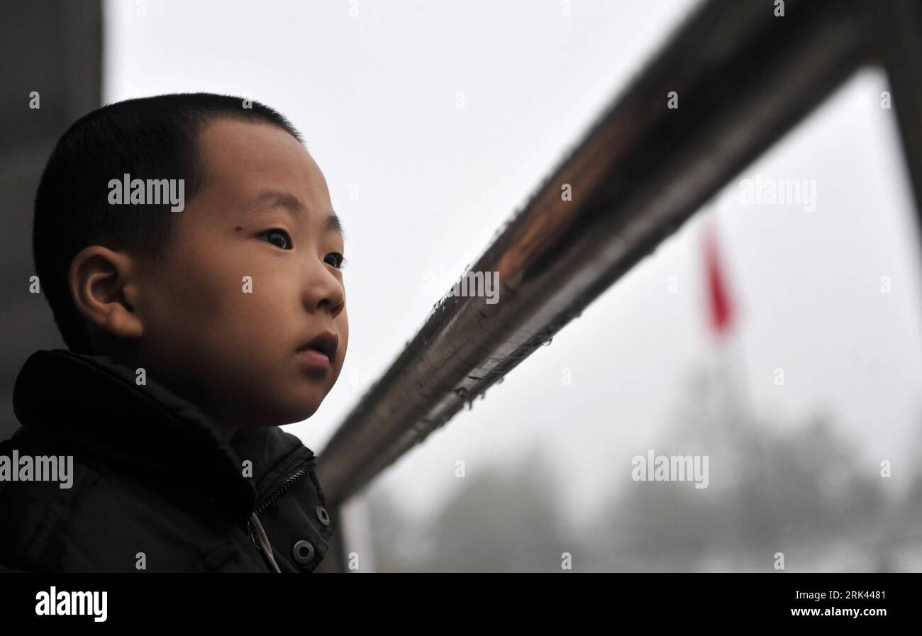 Bildnummer : 53585254 Datum : 12.10.2009 Copyright : imago/Xinhua (091108) -- ENSHI, 8 novembre 2009 (Xinhua) -- Zhu Xu semble droit alors qu'il pleut dehors à l'école dans le comté de Xianfeng à Enshi, province du Hubei en Chine centrale, 12 octobre 2009. Zhu Xu, âgé de huit ans, était élève de 3e année de l'école primaire Boyangping Nationality. Un enfant comme lui était censé vivre heureux avec ses parents, mais dans sa mémoire, il n'avait pas un tel bonheur. Son père Zhu Gang avait quitté la maison pour chercher du travail depuis 1994. En 2001, après la naissance de Zhu Xu, sa mère est également allée travailler à Chongqing, dans le sud-ouest de la Chine. Zhu co Banque D'Images