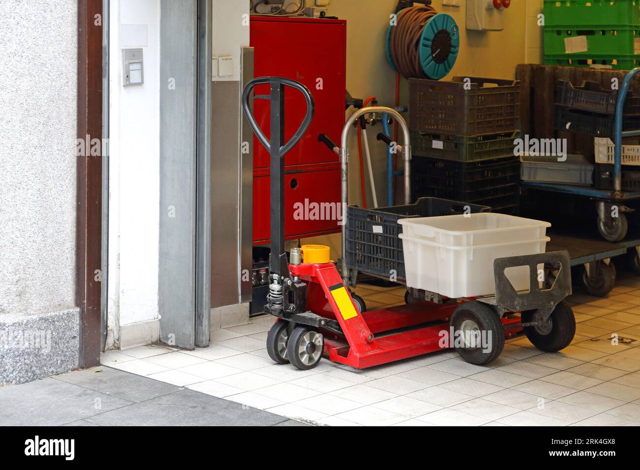 Chariot roulant et transpalette avec caisses dans la salle d'entreposage Banque D'Images