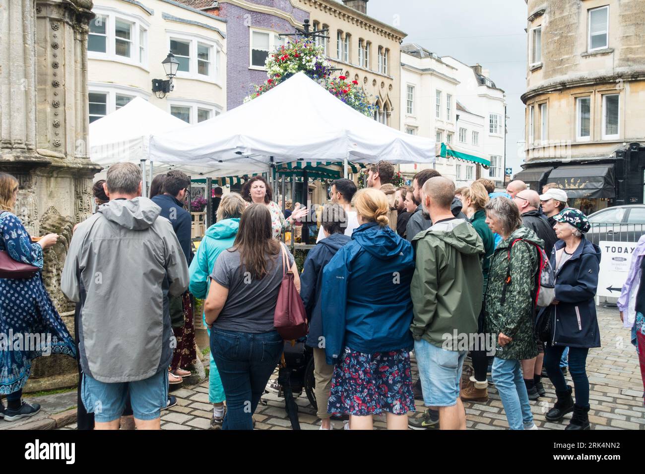 Touristes étant montré autour de Wells City Market Area, Wells, Somerset, Angleterre, Royaume-Uni. Banque D'Images
