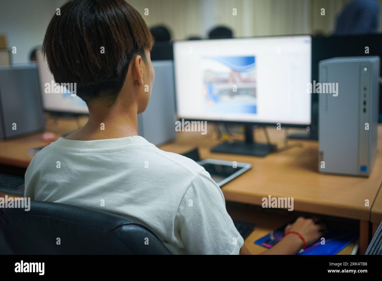 Un cliché sélectif de l'étudiant universitaire utilisant un ordinateur pendant qu'il étudiait dans la salle informatique Banque D'Images