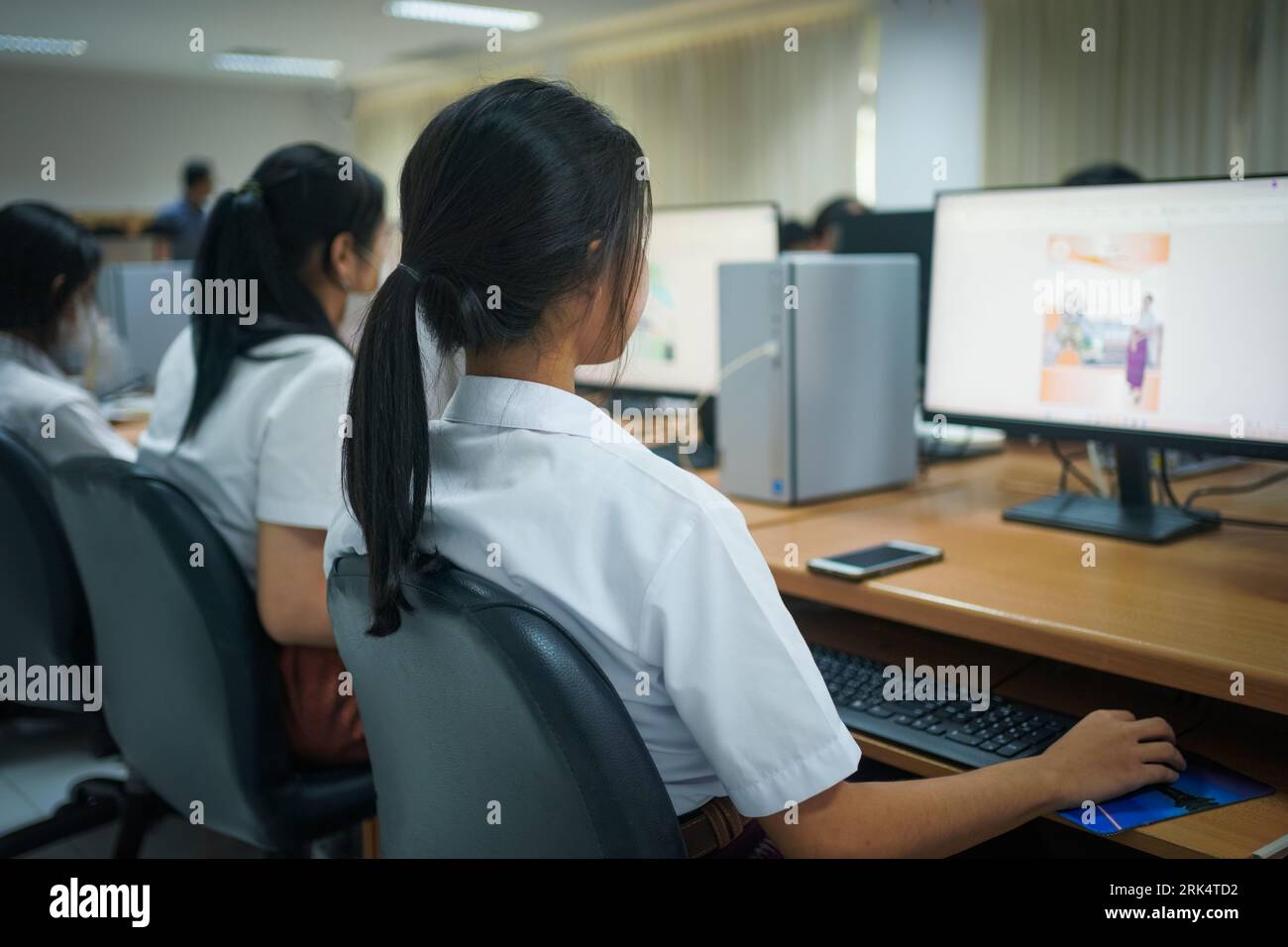 Un cliché sélectif de l'étudiant universitaire utilisant un ordinateur pendant qu'il étudiait dans la salle informatique Banque D'Images