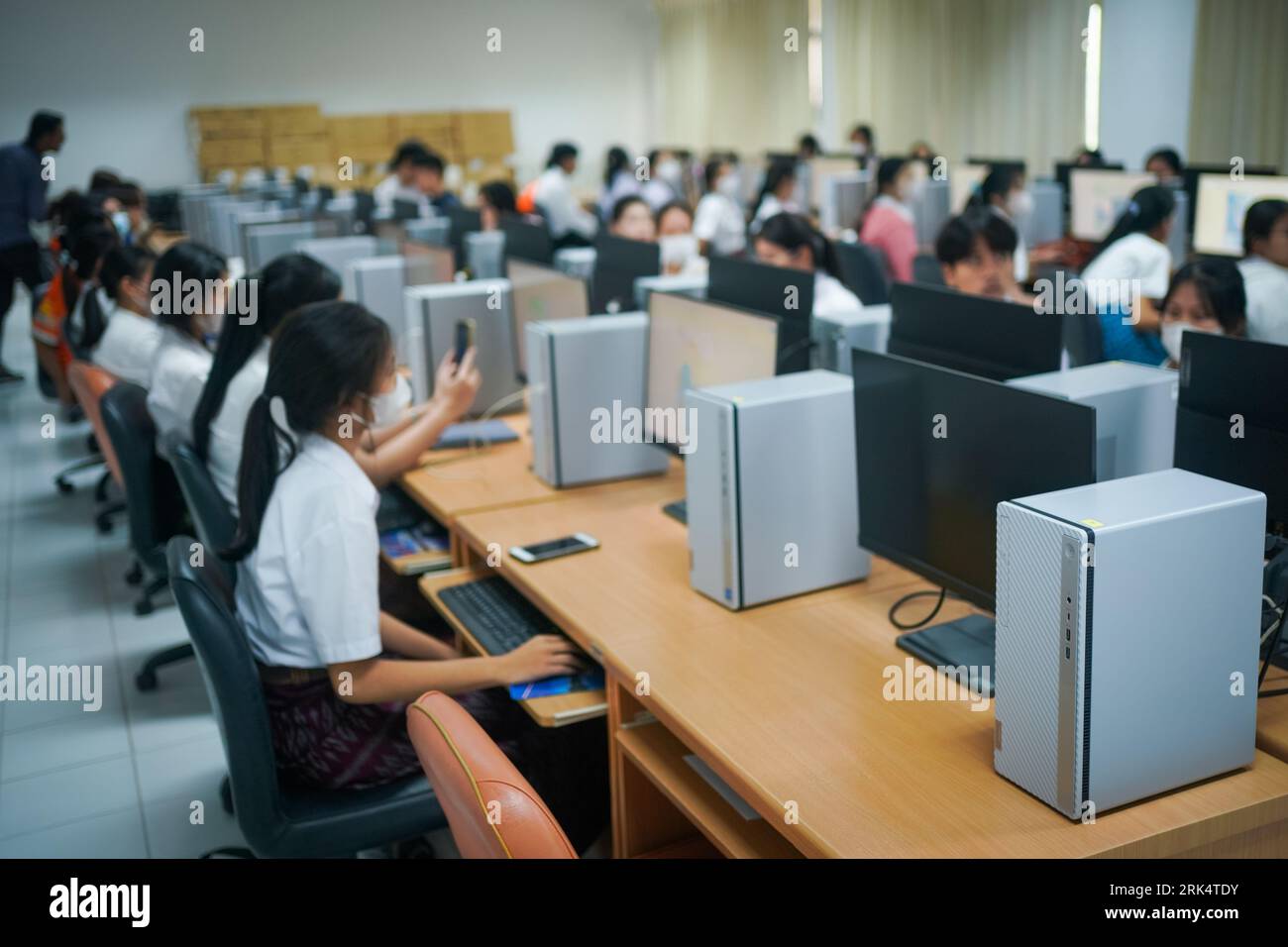 Un cliché sélectif de l'étudiant universitaire utilisant un ordinateur pendant qu'il étudiait dans la salle informatique Banque D'Images