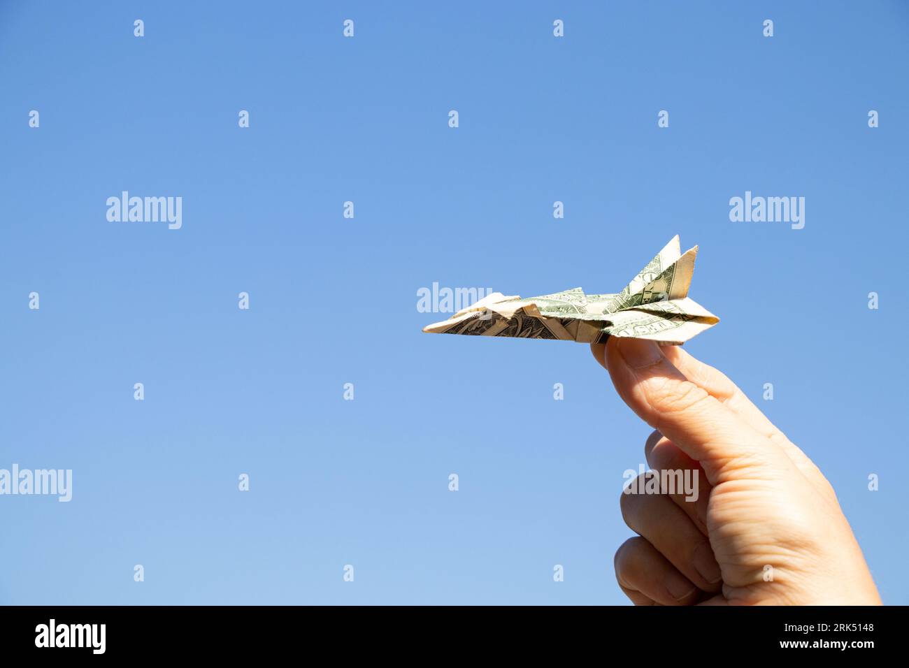 Avion d'un dollar dans la main d'une fille dans le ciel au-dessus de l'Ukraine, la liberté et la vie Banque D'Images