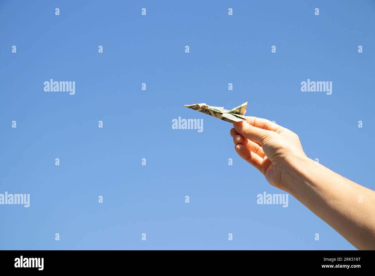 Avion d'un dollar dans la main d'une fille dans le ciel au-dessus de l'Ukraine, la liberté et la vie Banque D'Images