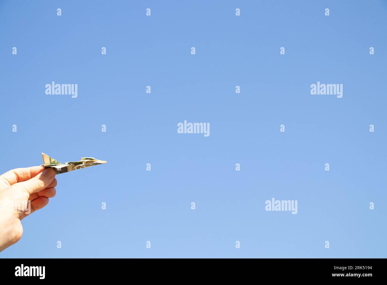 Avion d'un dollar dans la main d'une fille dans le ciel au-dessus de l'Ukraine, la liberté et la vie Banque D'Images