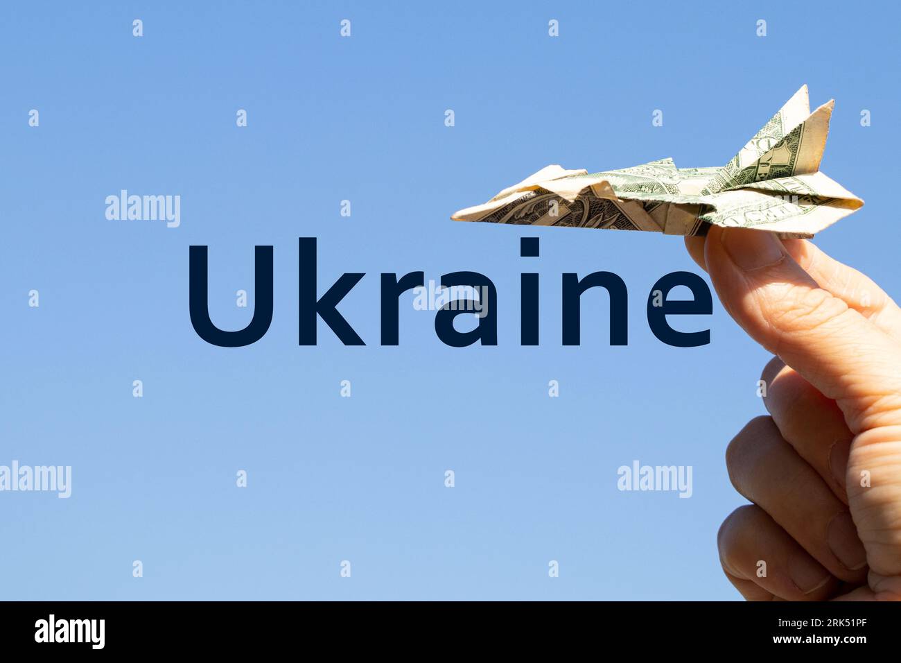 Avion d'un dollar dans la main d'une fille dans le ciel au-dessus de l'Ukraine et le texte Ukraine sur le fond, la liberté et la vie Banque D'Images