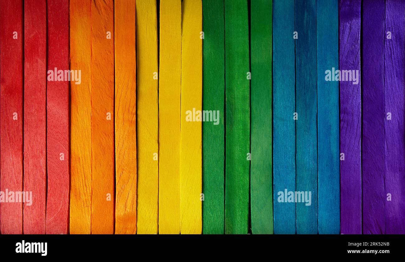 Fond en bois coloré et toile de fond avec une rangée verticale en bois avec des couleurs de drapeau lgbt arc-en-ciel. Banque D'Images