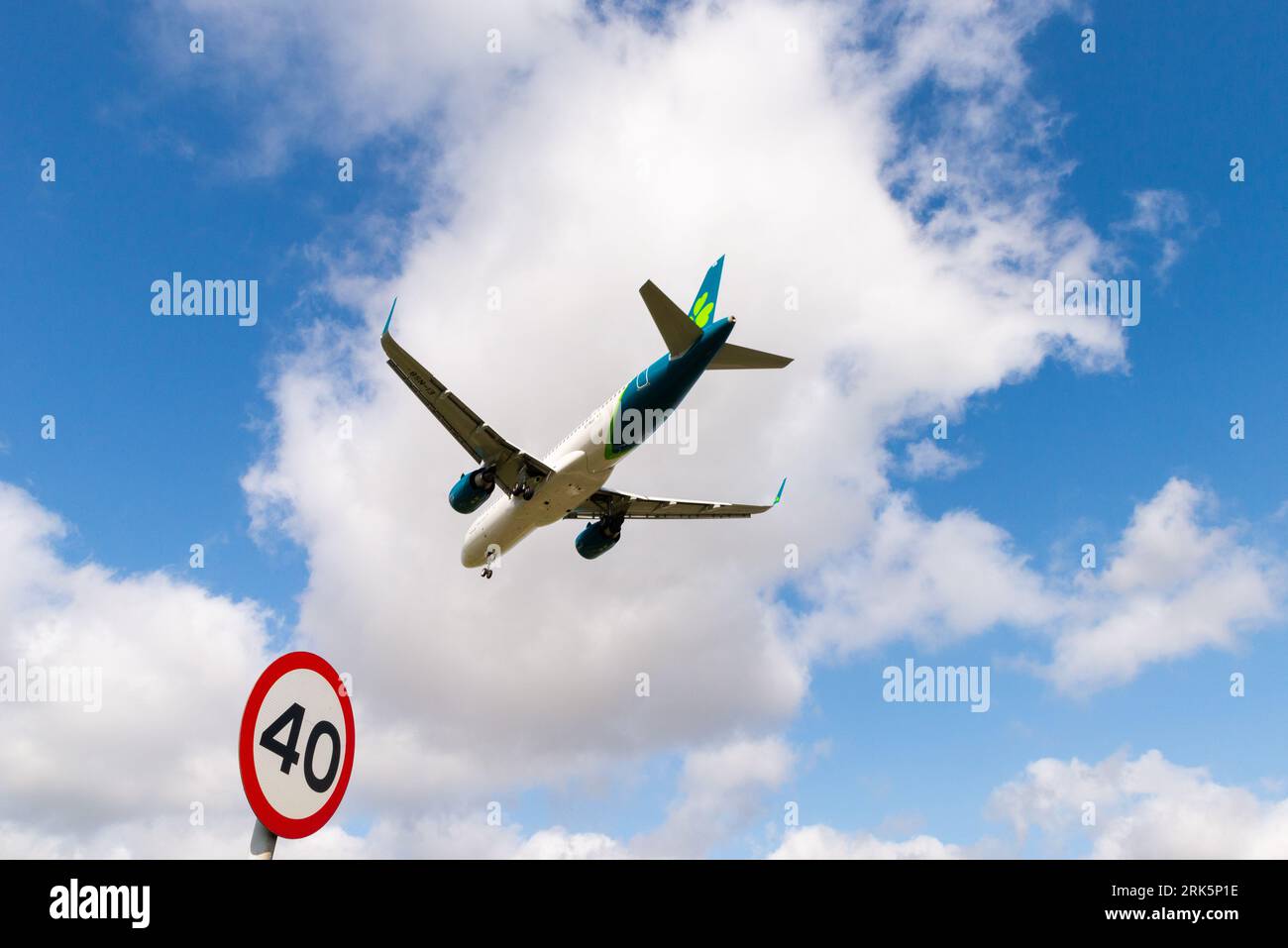Avion de ligne à réaction en finale pour atterrir à l'aéroport de Londres Heathrow, Royaume-Uni, en passant un panneau routier de 40 mph sur la route A30. limite de vitesse de 40 miles par heure Banque D'Images