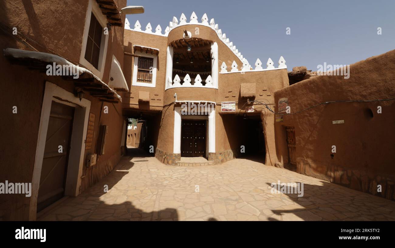 Une grande maison arabe traditionnelle avec un extérieur distinctif de couleur rouille, située dans un paysage naturel Banque D'Images
