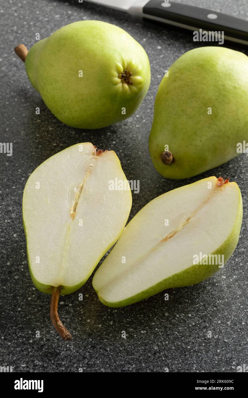 Poire à sucre douce fraîche entière et coupée en deux gros plan sur une planche à découper Banque D'Images