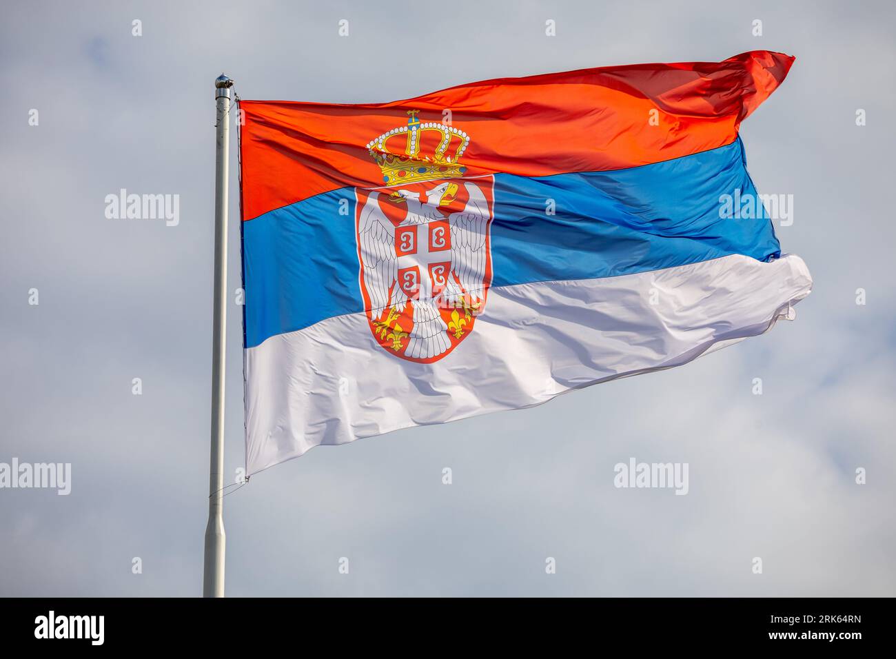 Drapeau national serbe sur vent, extérieur, fond nuageux Banque D'Images