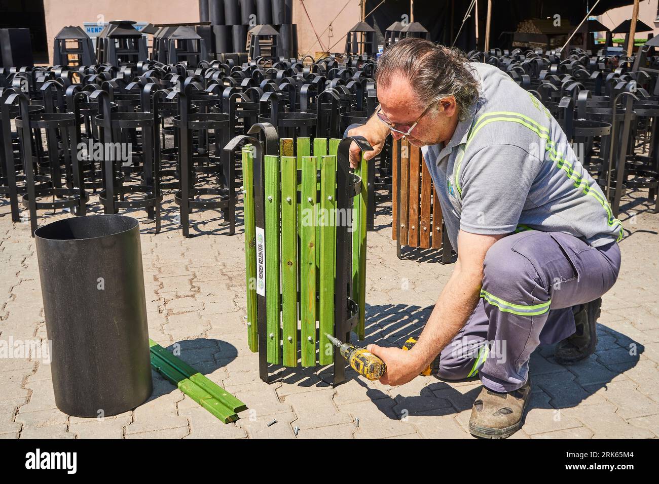 menuisier travaillant sur le bois dans un atelier. travailleur masculin avec un masque et un gilet de sécurité. menuiserie Banque D'Images