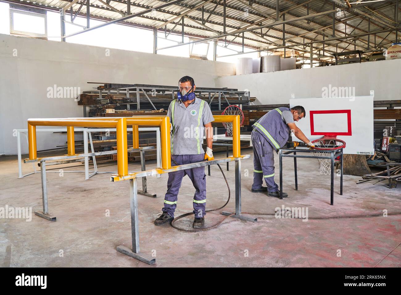 menuisier travaillant sur le bois dans un atelier. travailleur masculin avec un masque et un gilet de sécurité. menuiserie Banque D'Images
