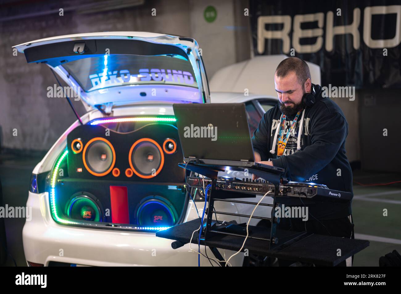 Un disque jokey jouant de la musique électronique avec la stéréo dans le coffre blanc Seat Ibiza 3 Banque D'Images