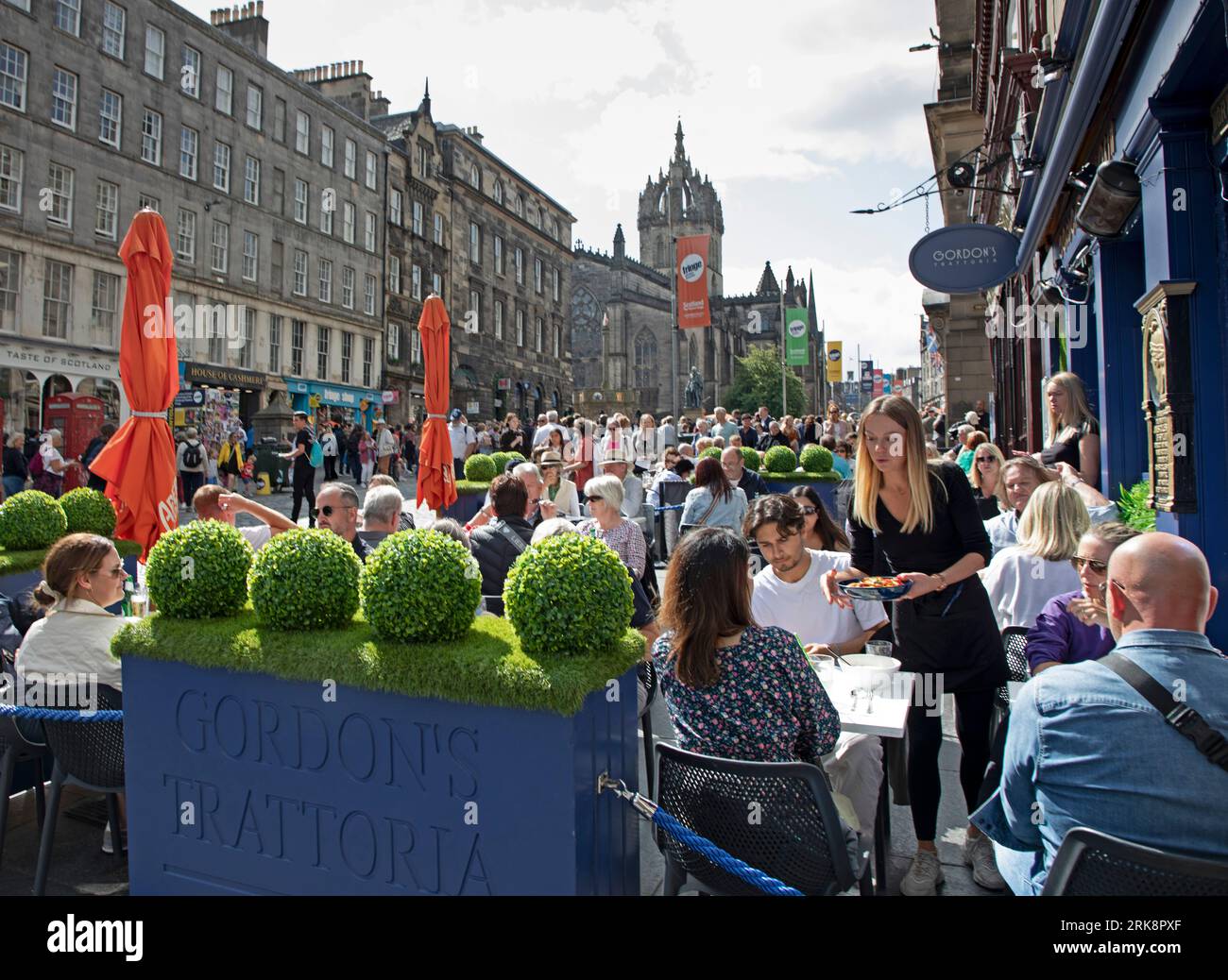Royal Mile, Édimbourg, Écosse, Royaume-Uni. 24 août 2023. Dernier jeudi ensoleillé pour les artistes de rue et ceux qui recherchent le divertissement sur la High Street de la capitale. Les rues sont plus calmes que prévu, ce qui laisse plus de place aux gens pour se déplacer. Température autour de 18 degrés centigrades. Photo : Gordon Trattoria fait de bonnes affaires au soleil. Crédit : Archwhite/alamy Live News. Banque D'Images
