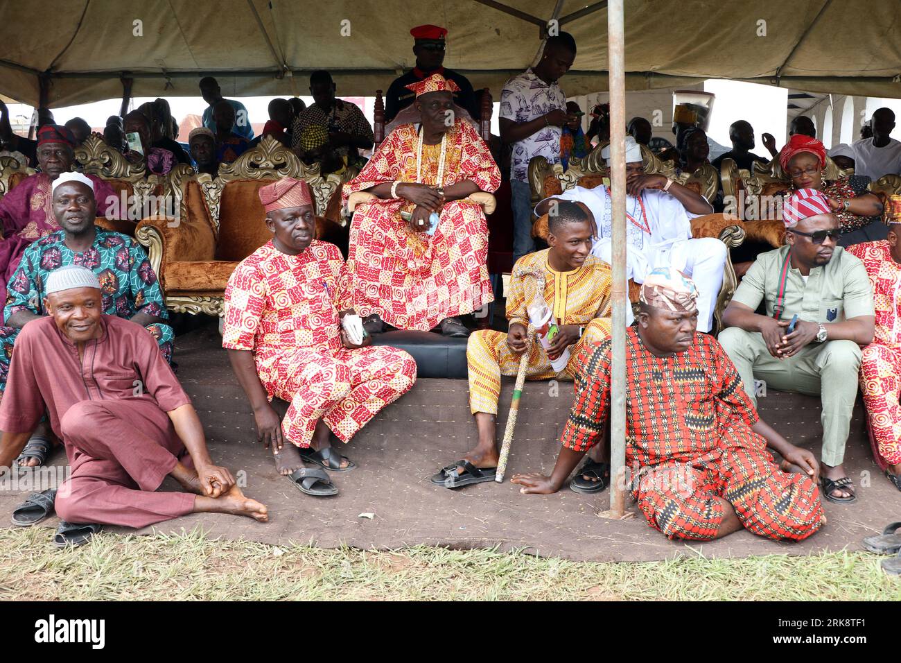 Les gardes du palais s'assoient autour d'un souverain traditionnel, Basorun d'Oyo, le haut chef Yusuf Akinade (M) au Festival mondial de sango qui est un festival annuel organisé par le peuple Yoruba en l'honneur de Sango, une divinité du tonnerre et du feu qui était un guerrier et le troisième roi de l'Empire Oyo après avoir succédé à Ajaka son frère aîné. Le festival accueille des visiteurs de tout le pays et des adeptes de pays étrangers. Etat d'Oyo, Lagos, Nigeria. Banque D'Images