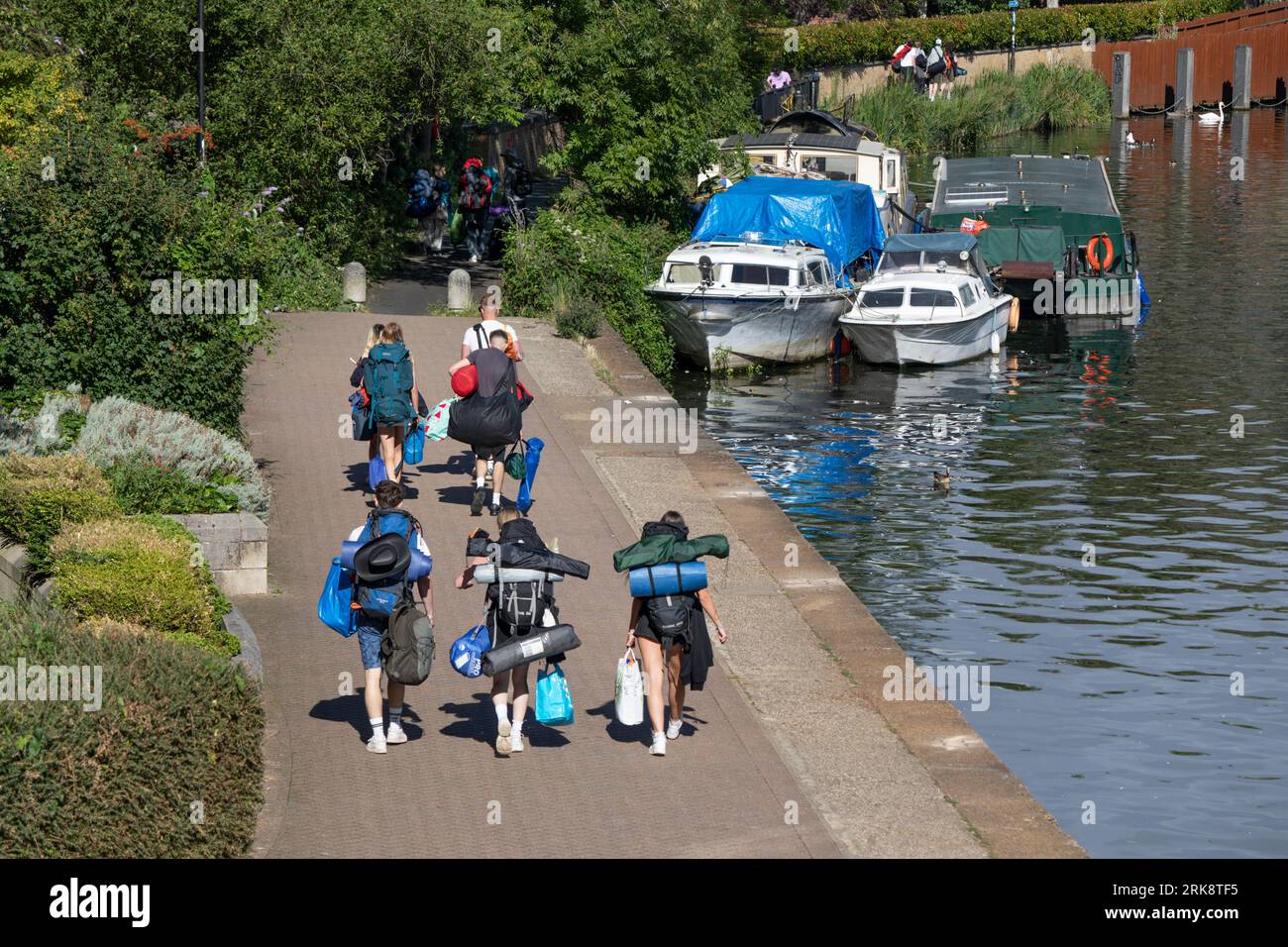 Jeunes marchant le long de la rive de la Tamise à Reading Festival, Reading, Berkshire, Angleterre, Royaume-Uni, Europe Banque D'Images