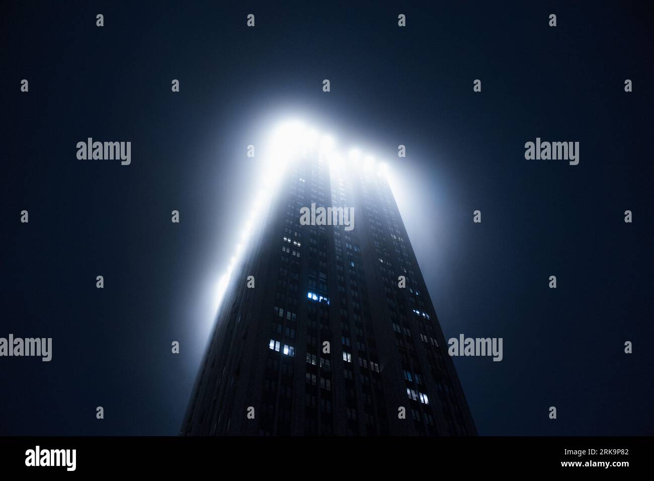 Grand gratte-ciel dans le brouillard entrant dans les nuages Banque D'Images