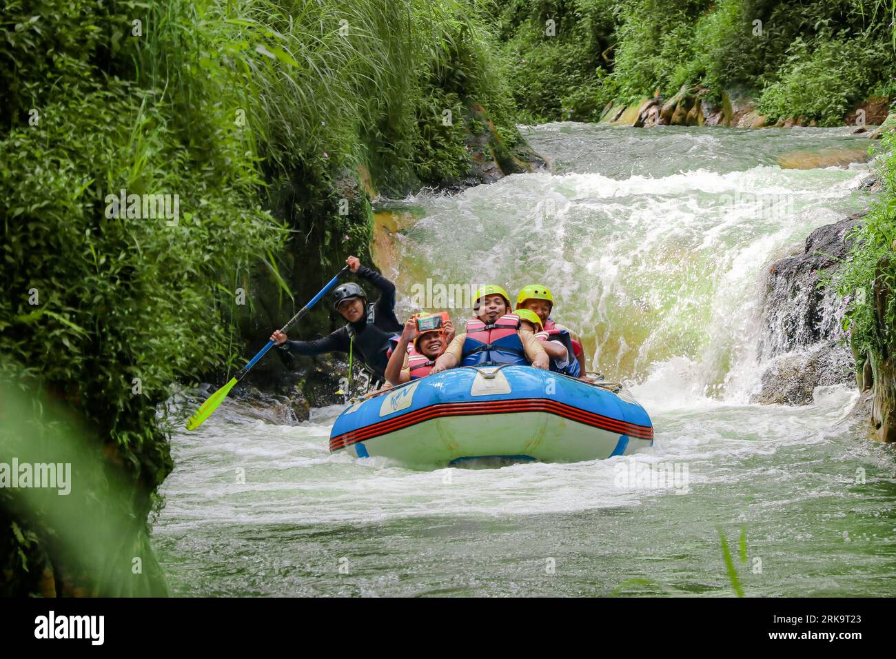 Pangalengan, Bandung-Indonésie décembre 2022 : Un groupe d'hommes et de femmes font du rafting sur la rivière, du sport extrême et amusant. Groupe de personnes sport nautique r Banque D'Images