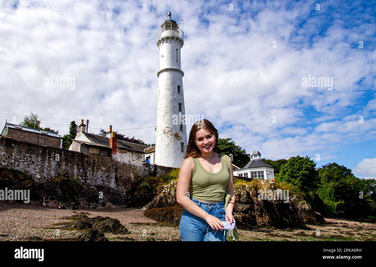 Image modifiée numériquement et modifiée dans Photoshop d'une femme Olivia (Lulu) Glen debout devant le phare de Tayport à Fife, en Écosse Banque D'Images