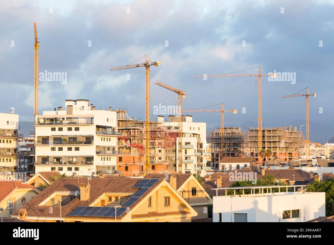 grues de construction entre bâtiments neufs et autres en construction ; image de spéculation immobilière Banque D'Images