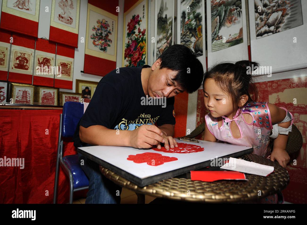Bildnummer : 54408083 Datum : 02.09.2010 Copyright : imago/Xinhua (100907) -- TAIYUAN, 7 septembre 2010 (Xinhua) -- Guo Shulin enseigne à sa fille l'art de la découpe du papier à Taiyuan, dans la province du Shanxi du nord de la Chine, le 2 septembre 2010. Il y a une célèbre famille de papier découpé à Taiyuan. Un couple nommé Guo Shulin et Wang Yinfeng, ainsi que leur fille Guo Yijing, consacrent leur vie à la découpe de papier traditionnelle chinoise. (Xinhua/Yan Yan) (wxy) CHINA-SHANXI-PAPER-CUT FAMILY (CN) PUBLICATIONxNOTxINxCHN Gesellschaft China Kunsthandwerk Fotostory kbdig xcb 2010 quer o0 Scherenschnitt, Papierschnitt, Tradition Banque D'Images