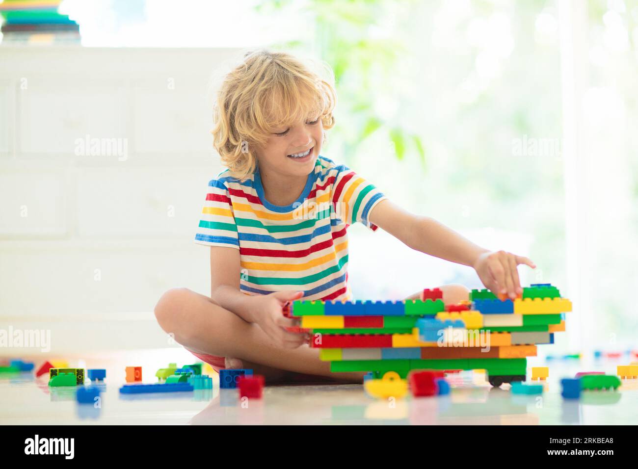 Les enfants jouent avec des blocs colorés. Tour de construction de petit garçon à la maison ou à la garderie. Jouet éducatif pour jeune enfant. Construction jeu créatif pour bébé Banque D'Images